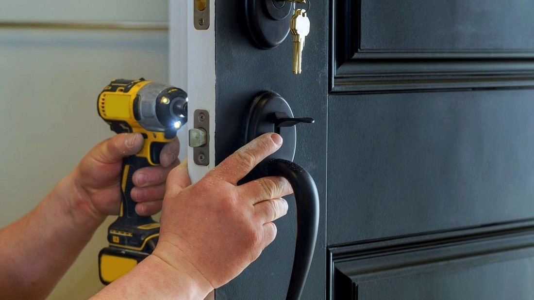 Locksmith fitting a new deadbolt into a prepared door edge