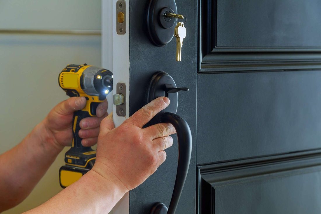 Locksmith fitting a new lock into a prepared door